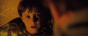 Movie still from “Matilda” (1996), directed by Danny DeVito – A child's face in a dark room; Close Up shot, Over the shoulder angle