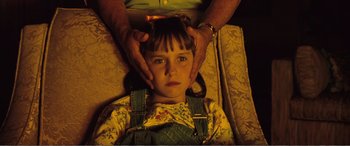 Movie still from “Matilda” (1996), directed by Danny DeVito – A child is getting a head massage from an acupuncturist; Close Up shot, Overhead angle