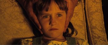 Movie still from “Matilda” (1996), directed by Danny DeVito – A person touching a young girl's face with their hands; Close Up shot, Overhead angle