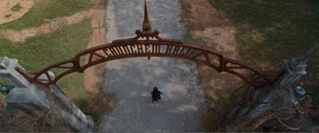 Movie still from “Matilda” (1996), directed by Danny DeVito – An overhead view of a person walking on a path under an arch; Extreme Wide shot, Overhead angle
