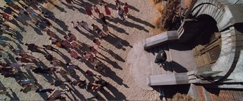 Movie still from “Matilda” (1996), directed by Danny DeVito – A group of people standing on a beach; Extreme Wide shot, Overhead angle