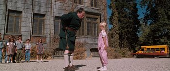 Movie still from “Matilda” (1996), directed by Danny DeVito – A man and a little girl standing next to each other; Medium shot, Low angle