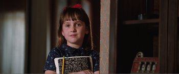 Movie still from “Matilda” (1996), directed by Danny DeVito – A young girl holding a notebook and pencil; Close Up shot, High angle