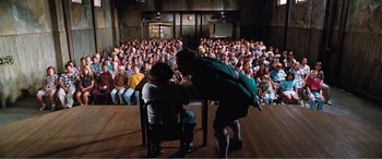 Movie still from “Matilda” (1996), directed by Danny DeVito – A man and a woman in front of an audience; Wide shot, High angle