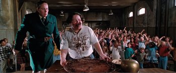 Movie still from “Matilda” (1996), directed by Danny DeVito – A woman with a messy face standing in front of a crowd; Wide shot, High angle