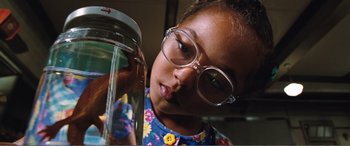 Movie still from “Matilda” (1996), directed by Danny DeVito – A young girl wearing glasses looking into a jar; Close Up shot, Low angle