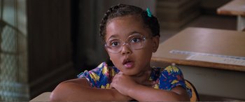 Movie still from “Matilda” (1996), directed by Danny DeVito – A little girl wearing glasses with her hand on her chin; Close Up shot, High angle