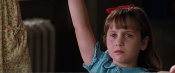 Movie still from “Matilda” (1996), directed by Danny DeVito – A young girl is holding her arm up in the air; Close Up shot, Low angle