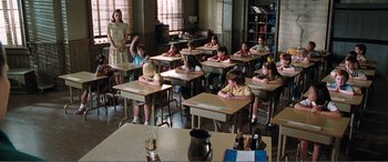 Movie still from “Matilda” (1996), directed by Danny DeVito – A classroom full of children sitting at desks; Wide shot, High angle