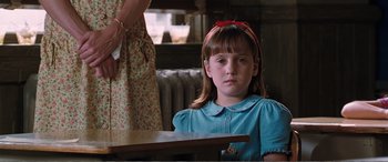 Movie still from “Matilda” (1996), directed by Danny DeVito – A young girl sitting at a table with a woman standing next to her; Close Up shot, Over the shoulder angle
