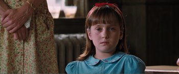 Movie still from “Matilda” (1996), directed by Danny DeVito – A young girl wearing a blue shirt and a red headband; Close Up shot, Over the shoulder angle