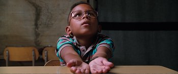 Movie still from “Matilda” (1996), directed by Danny DeVito – A little boy wearing glasses sitting at a table; Close Up shot, Low angle