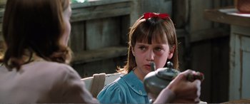 Movie still from “Matilda” (1996), directed by Danny DeVito – A young girl with a red bow in her hair; Close Up shot, Over the shoulder angle