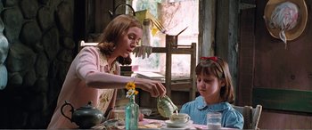 Movie still from “Matilda” (1996), directed by Danny DeVito – A woman pouring tea into a cup for a little girl; Medium shot, Low angle