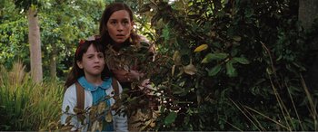 Movie still from “Matilda” (1996), directed by Danny DeVito – A woman and a child standing next to a tree; Medium shot, Low angle