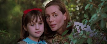 Movie still from “Matilda” (1996), directed by Danny DeVito – A woman and a young girl posing for a picture; Close Up shot, Over the shoulder angle