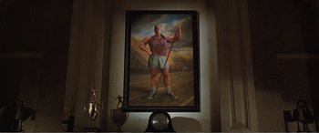 Movie still from “Matilda” (1996), directed by Danny DeVito – A painting of a man holding a spear in a field; Wide shot, Low angle