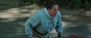 Movie still from “Matilda” (1996), directed by Danny DeVito – An older woman is running in the street; Medium shot, High angle