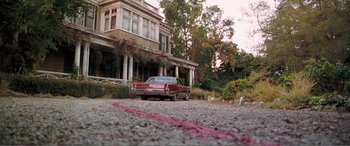 Movie still from “Matilda” (1996), directed by Danny DeVito – An old car parked in front of an old house; Extreme Wide shot, High angle