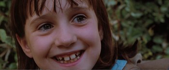 Movie still from “Matilda” (1996), directed by Danny DeVito – A young girl's smile with teeth missing; Close Up shot, Low angle