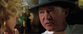 Movie still from “Matilda” (1996), directed by Danny DeVito – An older man wearing a black hat and a white shirt; Close Up shot, Low angle
