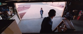 Movie still from “Matilda” (1996), directed by Danny DeVito – A man and a boy are standing in a driveway; Wide shot, Over the shoulder angle