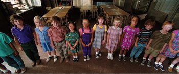 Movie still from “Matilda” (1996), directed by Danny DeVito – A group of children standing in a row in front of a table; Wide shot, High angle