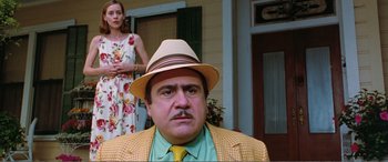 Movie still from “Matilda” (1996), directed by Danny DeVito – A man in a yellow suit and a woman in a floral dress; Medium shot, Low angle