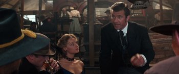 Movie still from “Maverick” (1994), directed by Richard Donner – A man and a woman standing next to each other in a room; Medium shot, Over the shoulder angle