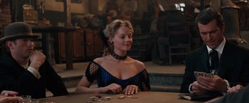 Movie still from “Maverick” (1994), directed by Richard Donner – A woman sitting at a table in front of a bunch of coins; Medium shot, Over the shoulder angle