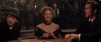 Movie still from “Maverick” (1994), directed by Richard Donner – A woman sitting at a table in front of other people; Medium shot, Over the shoulder angle