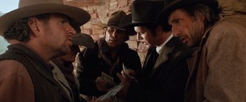 Movie still from “Maverick” (1994), directed by Richard Donner – A group of men standing next to a brick wall; Medium shot, Low angle