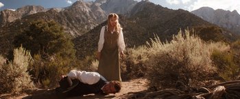 Movie still from “Maverick” (1994), directed by Richard Donner – A woman standing next to a man laying on the ground; Wide shot, Low angle