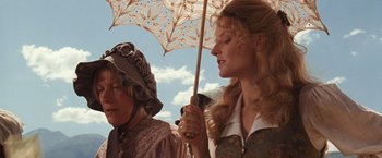 Movie still from “Maverick” (1994), directed by Richard Donner – Two women are standing under an open umbrella; Close Up shot, Low angle