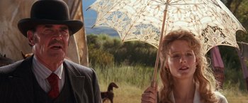 Movie still from “Maverick” (1994), directed by Richard Donner – A woman holding an umbrella while standing next to a man; Close Up shot, Low angle