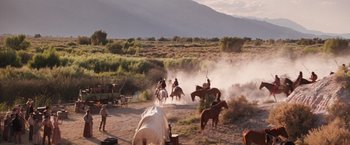 Movie still from “Maverick” (1994), directed by Richard Donner – A group of people riding horses on a dirt field; Extreme Wide shot, High angle