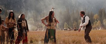 Movie still from “Maverick” (1994), directed by Richard Donner – A man in native american garb standing in a field; Wide shot, Low angle