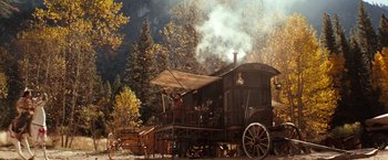 Movie still from “Maverick” (1994), directed by Richard Donner – An old fashioned steam powered wagon with a horse drawn carriage; Extreme Wide shot, Low angle