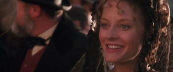 Movie still from “Maverick” (1994), directed by Richard Donner – A woman smiling at the camera; Close Up shot, Over the shoulder angle