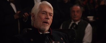 Movie still from “Maverick” (1994), directed by Richard Donner – An older man with white hair wearing a black jacket; Close Up shot, Over the shoulder angle