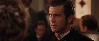 Movie still from “Maverick” (1994), directed by Richard Donner – A person wearing a suit and tie; Close Up shot, Over the shoulder angle