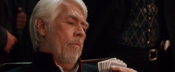 Movie still from “Maverick” (1994), directed by Richard Donner – An older man holding a stack of money; Close Up shot, Low angle
