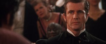 Movie still from “Maverick” (1994), directed by Richard Donner – A person wearing a suit and tie; Close Up shot, Over the shoulder angle