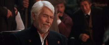 Movie still from “Maverick” (1994), directed by Richard Donner – An older man with white hair and a white beard; Close Up shot, Over the shoulder angle