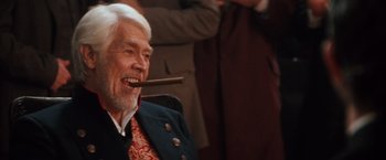 Movie still from “Maverick” (1994), directed by Richard Donner – An older man holding a cigar in his mouth; Close Up shot, Over the shoulder angle