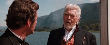 Movie still from “Maverick” (1994), directed by Richard Donner – A man in a suit and a man with a beard talking to each other; Close Up shot, Over the shoulder angle