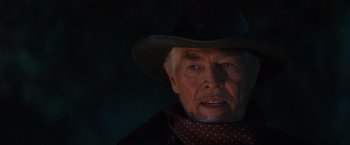 Movie still from “Maverick” (1994), directed by Richard Donner – An older man wearing a cowboy hat and a scarf; Close Up shot, Over the shoulder angle