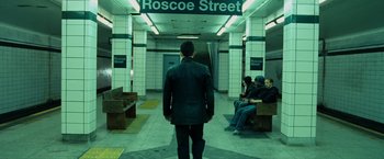 Movie still from “Max Payne” (2008), directed by John Moore – A man in a suit standing in front of a train platform; Wide shot, High angle