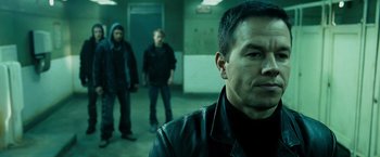 Movie still from “Max Payne” (2008), directed by John Moore – A man in a black leather jacket standing next to two other men; Close Up shot, Over the shoulder angle