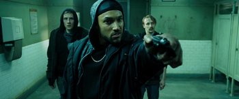 Movie still from “Max Payne” (2008), directed by John Moore – A group of men standing next to each other holding guns; Medium shot, Over the shoulder angle